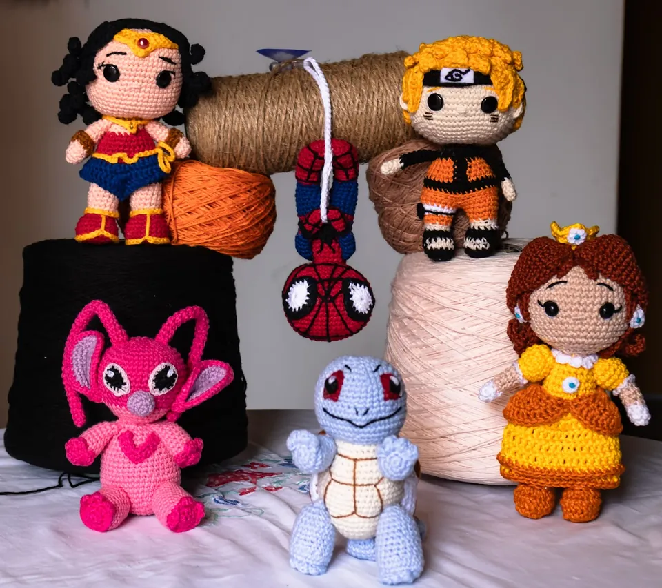 Amigurumis de personajes tejidos a crochet sobre conos de hilo