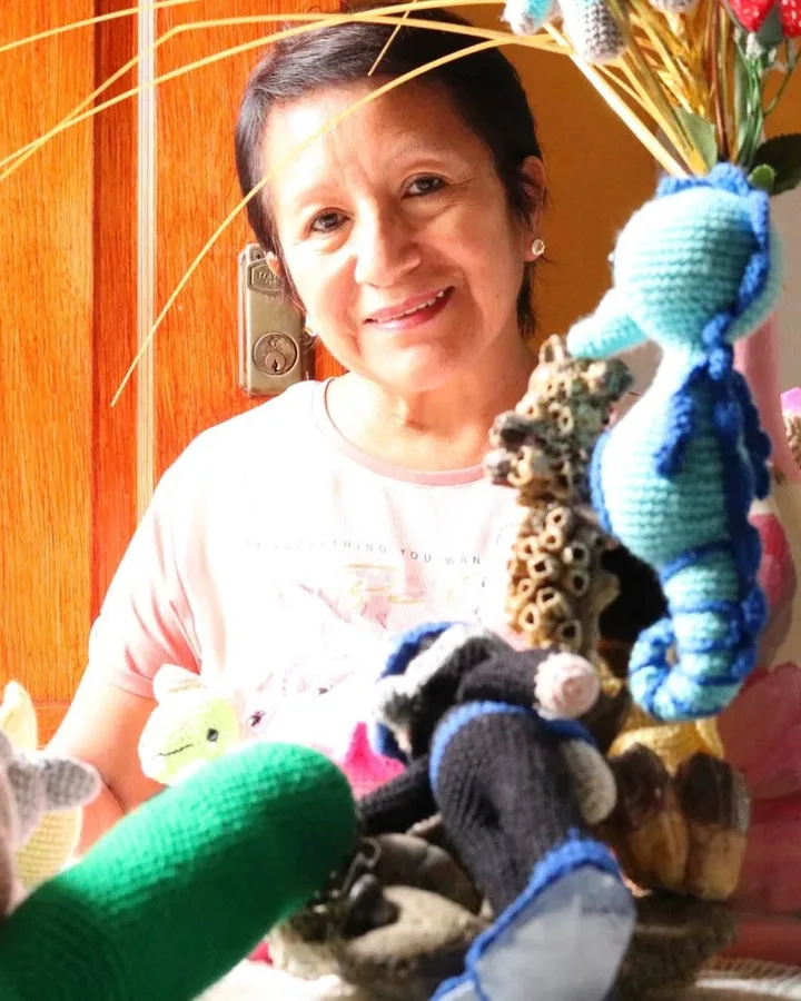 Pili sonriendo junto a sus amigurumis tejidos a crochet